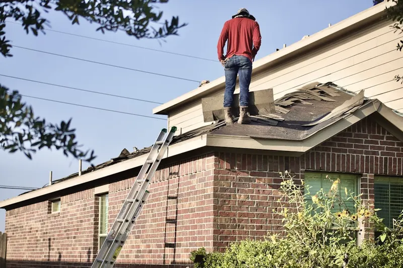 Professional roofer working on a residential roof in Homes Mills